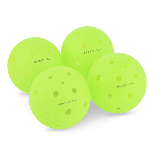 Four green pickleball balls with Selkirk branding on a white background
